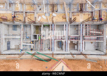 Luftaufnahme der Gruppe der Bauarbeiter Gebäude im Bau. Stockfoto