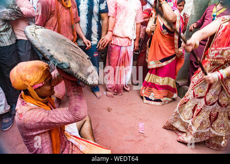 Barsana, Indien - 24. Februar 2018 - Lathmar Holi Festival - Frauen schlagen Männer mit Bambusstäben, bis man aufgibt Stockfoto