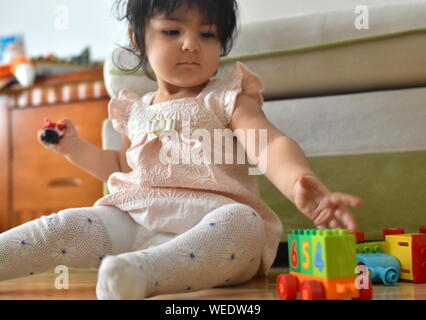 Cute Baby Mädchen spielt mit den Spielsachen im Kinderzimmer Stockfoto