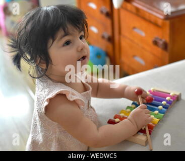 Cute Baby Mädchen spielen Musik auf Spielzeug Xylophon Stockfoto