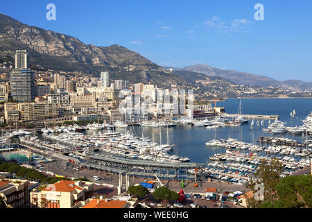 Schiffe in der Bucht von Monaco auf blauem Hintergrund. Stadt Häuser Hintergrund. Stockfoto