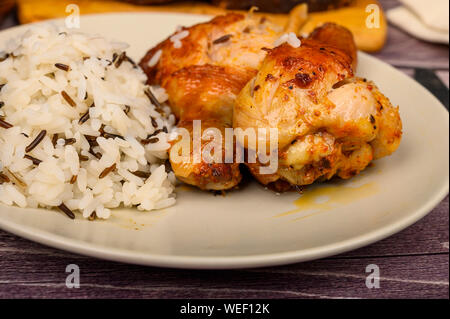 Hähnchenschenkel mit Gewürzen gebraten in einen Kessel, serviert auf einem Teller mit Reis. Stockfoto