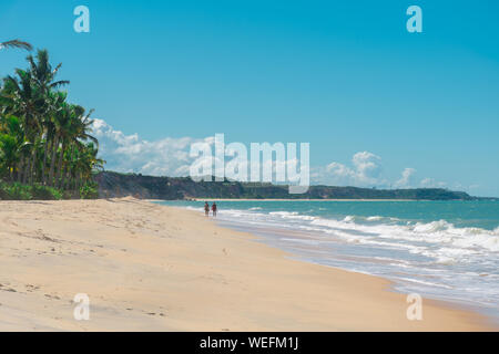 BAHIA, BRASILIEN - 27. Juni 2019: romantische und malerische Aussicht auf ein paar wenige Seite an Seite in der Nähe des Meer und Palmen in der tropischen Umgebung eines Beac Stockfoto