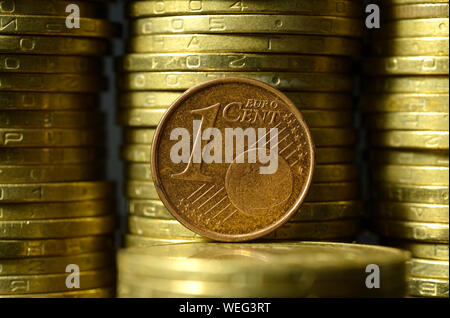 Ein Euro Cent Münze auf der Kante vor Stapel von Münzen platziert Stockfoto