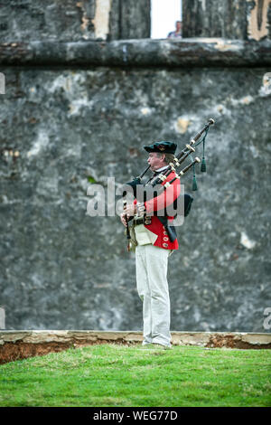 Militärische reenactor spielt Dudelsack in Ca. späten 1700s Uniform, San Felipe del Morro Castle (1540s-1786), San Juan National Historic Site, Old San Juan, Stockfoto