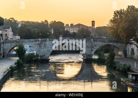 Sonnenaufgang über dem Tiber und Ponte Cestio mit dem Glockenturm von Santa Maria in Cosmedin in der Ferne, Rom, Italien. Stockfoto