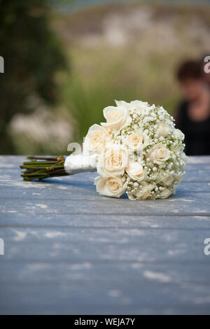Blumenstrauß aus Rosen für Hochzeit auf sandigen Promenade für Hochzeit am Strand Stockfoto