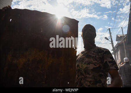 Srinagar, Jammu und Kaschmir, Indien. 23 Aug, 2019. Silhouette eines Kaschmirischen Maskierter Demonstrant, während der Demonstration. Hunderte von Menschen an einer Demonstration nach dem Freitagsgebet in der Soura Nachbarschaft. Spannungen eskalieren, da die indische Regierung eine teilweise Autonomie der Region vor drei Wochen entfernt. Informationen hat auch knapp, wie Internet und mobile Netze meist blockiert wurden. Kredit Idrees: Abbas/SOPA Images/ZUMA Draht/Alamy leben Nachrichten Stockfoto