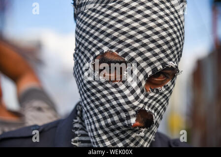 Srinagar, Jammu und Kaschmir, Indien. 23 Aug, 2019. Ein Maskierter Demonstrant in Kaschmir, während der Demonstration. Hunderte von Menschen an einer Demonstration nach dem Freitagsgebet in der Soura Nachbarschaft. Spannungen eskalieren, da die indische Regierung eine teilweise Autonomie der Region vor drei Wochen entfernt. Informationen hat auch knapp, wie Internet und mobile Netze meist blockiert wurden. Kredit Idrees: Abbas/SOPA Images/ZUMA Draht/Alamy leben Nachrichten Stockfoto