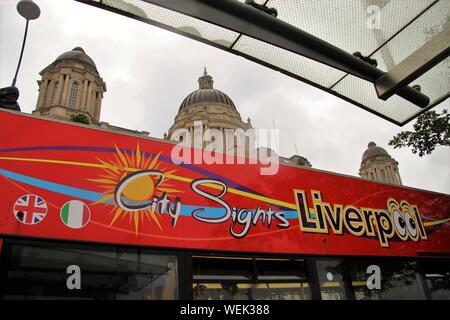 Touristische Bus vor dem Royal Liver Building. Am Pier Head, an der Waterfront von Liverpool. England, Europa. Stockfoto