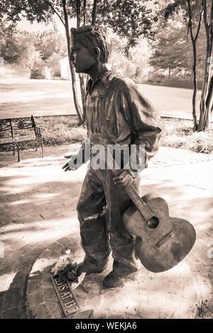 Eine Bronzestatue des 13 Jahre alten Elvis mit Gitarre steht auf dem Weg Besichtigung der Elvis Presley Birthplace Museum gründen in Tupelo, MS, USA Stockfoto