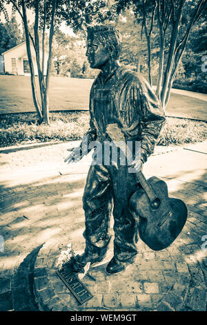 Eine Bronzestatue des 13 Jahre alten Elvis mit Gitarre steht auf dem Weg Besichtigung der Elvis Presley Birthplace Museum gründen in Tupelo, MS, USA Stockfoto