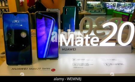 BANGKOK, THAILAND - 11. MAI 2019: Hände auf Huawei Hassen 20 Serie, willkommen und verfügt über Bildschirm des Smartphones im Einzelhandel shop in Ban zeigen Stockfoto