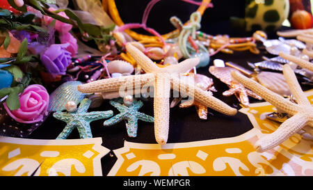 Satz von verschiedenen blauen Muscheln, Seesterne, Pearl und Blumen auf schwarzem Hintergrund für Nacht Party Dekoration Stockfoto