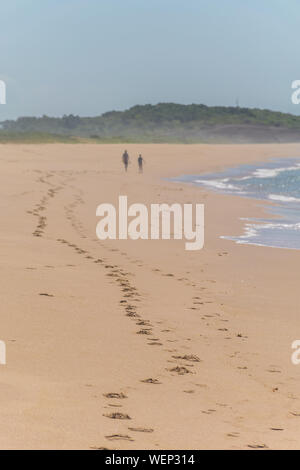 Ein Zick-zack-Spur von Fußabdrücken, zwei Leute neben dem Atlantischen Ozean, es gibt einen Hügel und Natur Vegetation in der Extremität am Strand von Paulo Ceza Stockfoto