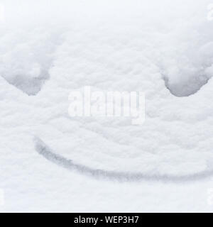 Lustige Schnee Lächeln auf dem weißen Schnee Hintergrund gemalt, happy winter Konzept. Stockfoto
