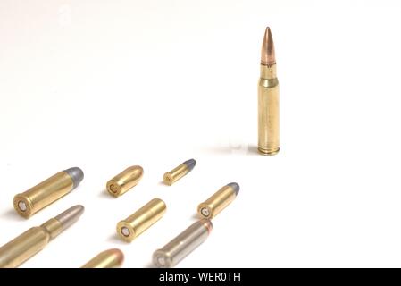 Große bullet führenden mehrere kleinere Kugeln Festlegung auf eine weiße Fläche. Es funktioniert wie ein Konzept für Führung, Kriminalität, Wettrüsten. Stockfoto
