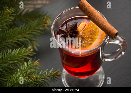 Weihnachten Tradition trinken. Heißer Glühwein mit Zimt und Weihnachtsbaum auf schwarzem Schiefer Teller. Close Up, kopieren. Stockfoto