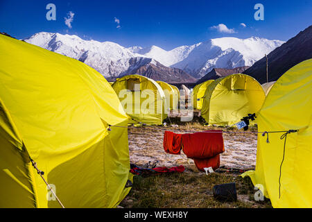 BaseCamp auf Peak Lenin, Kirgisistan. 48 gelbe Zelte bieten in den Monaten Juli und August Platz für etwa 100 Gäste. Während des restlichen Jahres ist das hügelige Tal, das sich auf einer Höhe von 3.600 Metern befindet, im Sommer nicht mehr mit den Shuttlebussen erreichbar, die das Basislager direkt vom 330 km entfernten Flughafen Osh hierher bringen
