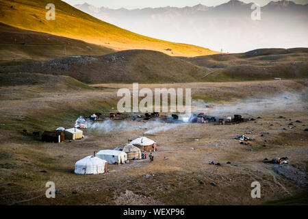 Nomaden in Jurten auf dem Gipfel von Lenin, Kirgisistan. Ein neuer Tag beginnt für die nomadische Kirgisische Familie am Fuße des Pamir-Gebirges Stockfoto