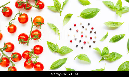 Frische Tomaten mit Basilikum und verschiedene Pfefferkörner auf weißem Hintergrund. Ansicht von oben Stockfoto