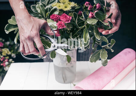 Florist im Werk. Frauenhände, eine Hochzeit Strauß Rosen. Small Business Konzept Stockfoto