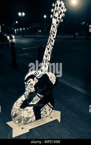 Eine von vielen Gitarre Skulpturen auf der Main Street in der Nacht ehren Heimatstadt Legende, Elvis Presely homecoming Leistung, in der Innenstadt von Tupelo, MS, Stockfoto