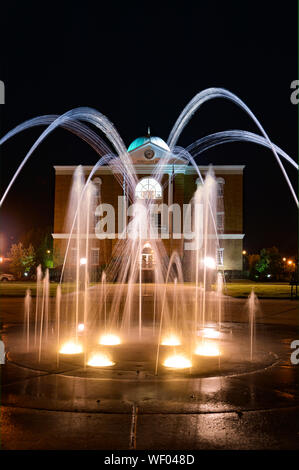 Hier mal einen Blick auf Tupelo Rathaus Gebäude mit Tülle Brunnen mit Beleuchtung im Vordergrund, in Elvis Heimatstadt, Tupelo, MS, USA Stockfoto