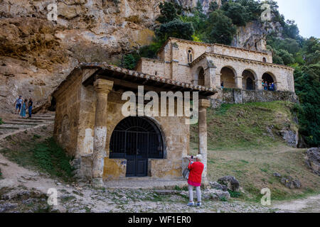 Weibliche Touristen Kapelle de las Ánimas del Santo Cristo mit der Ermita de Santa María de la Hoz im Hintergrund, Tobera, Provinz Burgos, Spanien Stockfoto