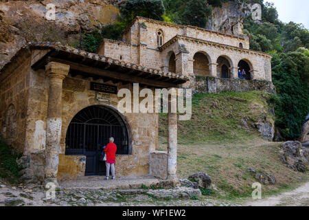 Weibliche Touristen Kapelle de las Ánimas del Santo Cristo mit der Ermita de Santa María de la Hoz im Hintergrund, Tobera, Provinz Burgos, Spanien Stockfoto