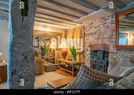 Das Teehaus Lounge Zimmer im Landhausstil und Holzbalken an der Decke Wand und goldenen Farbton Beleuchtung im Spiegel Roggen Vereinigtes Königreich wider. Stockfoto