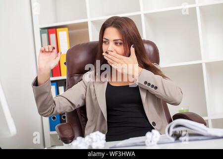 Junge langweilig Geschäftsfrau am Tisch mit Laptop sitzen und schlafen wollen, während Gähnen am Arbeitsplatz in modernen Büro. Stockfoto