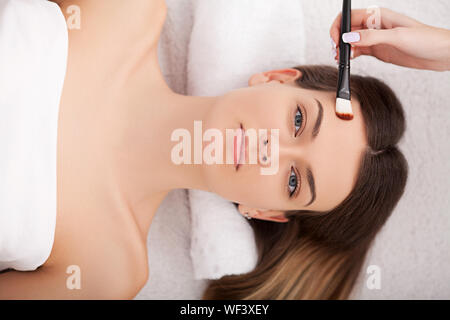 Hardware Kosmetologie. Closeup Bild der reizende junge Frau mit Creme Maske in einem Schönheitssalon. Stockfoto