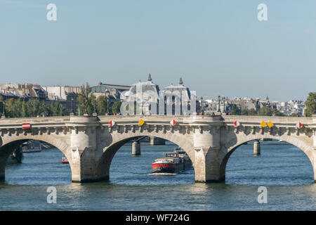 Überblick über die Architektur von einem weißen Brücke mit gelben und roten Dekorationen über die Seine in Paris mit dem Transport die vorüberziehenden Boote Stockfoto