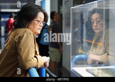 New London, CT/USA - Juni 22, 2019: asiatische Frau mittleren Alters Besucher stellt eine Ausstellung in der U-Force Museum Stockfoto