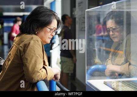 New London, CT/USA - Juni 22, 2019: asiatische Frau mittleren Alters Besucher stellt eine Ausstellung in der U-Force Museum Stockfoto