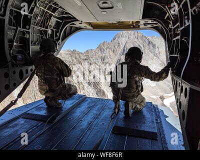 Ein paar der US-Armee Soldaten zu B-Company, 1.BATAILLON, 126 Aviation Regiment, Oklahoma Army National Guard zugeordnet, schauen Sie heraus aus der CH-47F Chinook Hubschrauber während eines Rescue Mission, 12.08.25, 2019, auf dem Mount Whitney im Inyo County, Kalifornien fliegen. Bei 14.500 Fuß, der Berg ist der höchste Gipfel in der aneinandergrenzenden Staaten der USA. Cal Guard unterstützt lokale, staatliche und föderale Agenturen während des Such- und Rettungsmissionen und inländischen Disaster Response Bemühungen. (Foto mit freundlicher Genehmigung Inyo County Suche und Rettung) Stockfoto