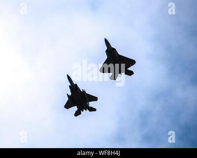 Eine F-15C Eagle von der 173th Fighter Wing und ein California Air National Guard F-22 Raptor fliegen in Formation über Joint Base Pearl Harbor-Hickam, Hawaii, Aug 21, 2019 während Fighter übung Sentry Aloha 19-2. Die Übung beinhaltet Rücken-an-Rücken bekämpfen Sorties mit Besuch Flugzeuge von Air National Guard Einheiten und die Royal Australian Air Force. Sentry Aloha bietet den Teilnehmern eine facettenreiche, gemeinsamen Schauplatz mit Unterstützung der Infrastruktur und Personal. (U.S. Air National Guard Foto von älteren Flieger John linzmeier) Stockfoto