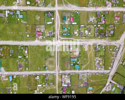 Private Häuser in einem Dorf oder in einem Ferienhaus Dorf unter grünen Bäumen und Gras im Altai Gebirge im Sommer Stockfoto