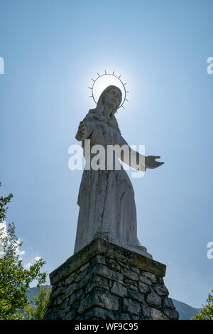 Malcesine, Italien - Juli 26,2019: Die Statue der Madonna dell'accoglienza mit Blick auf die Altstadt von Malcesine in Italien Stockfoto