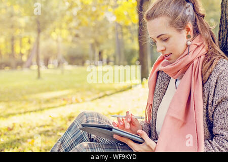 Wirkliche Geschäftsfrau mit Tablet Notebook bei der Arbeit im Freien in Park Stockfoto