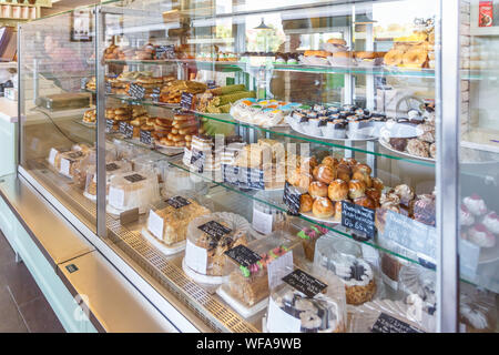 GRODNO, Weißrussland - AUGUST 2019: cafeteria Fenster mit Torten, Gebäck, Eis, Gebäck, Waffeln, Donuts, Kuchen und andere Süßigkeiten in einem angesagten Café Stockfoto