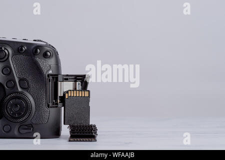 Professionelle Fotografie Ausrüstung. SD-Karten neben DSLR-Kamera. Stockfoto