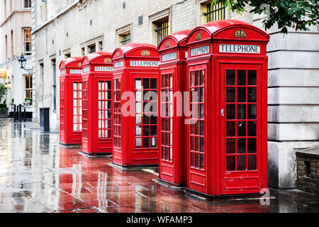 Fünf britischen roten Telefonzellen in einer Reihe. Eine Reihe von Telefonzellen in Covent Garden nach dem Regen. Stockfoto