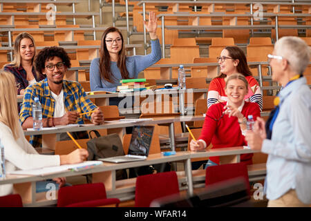 Studenten steigende Hände die Frage im Vortrag im Klassenzimmer zu beantworten Stockfoto