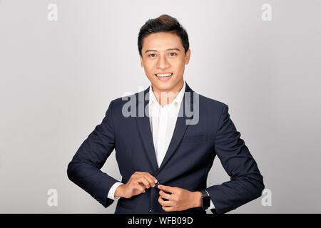 Asiatische Geschäftsmann setzt auf eine Klage. Close-up Business stilvollen Mann zuzuknöpfen seine Jacke. Stockfoto