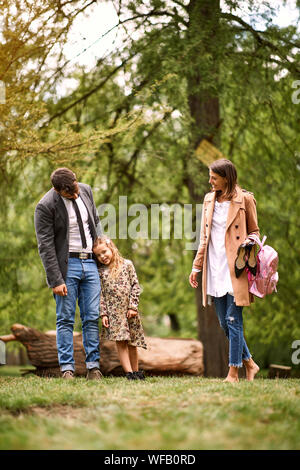 Glückliche junge Familie im Park nach Schule und Unternehmen. Stockfoto