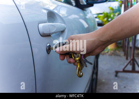 Selektiver Fokus auf dem Schlüssel remote und Werkzeuge in der Hand des Menschen die Autotür öffnen. leben Konzept. Close-up High resolution Image Gallery. Stockfoto