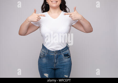 7/8-Ansicht von Brünette in weißem Hemd und Jeans Stockfoto