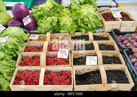 Johannisbeere Beeren in kleinen Körben und Kopfsalat für den Verkauf auf dem Markt Stockfoto